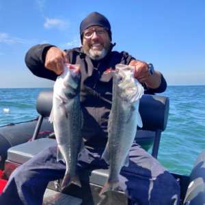 Dante est sur son zodiac en mer aux alentours de Saint-Michel-Chef-Chef. Il est assis et tient deux bar, un dans chaque main.